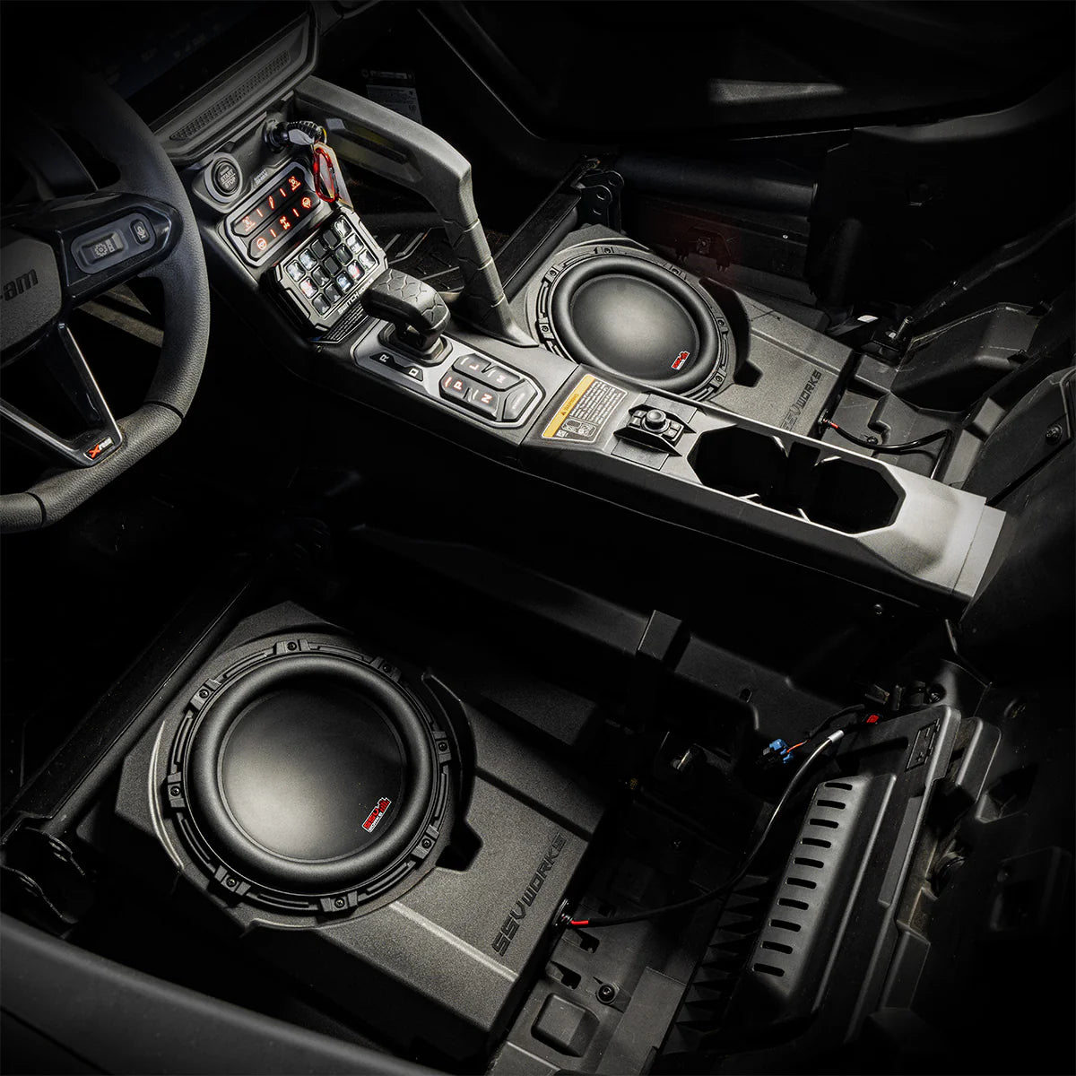 Car interior with subwoofers installed in the floor and dashboard.