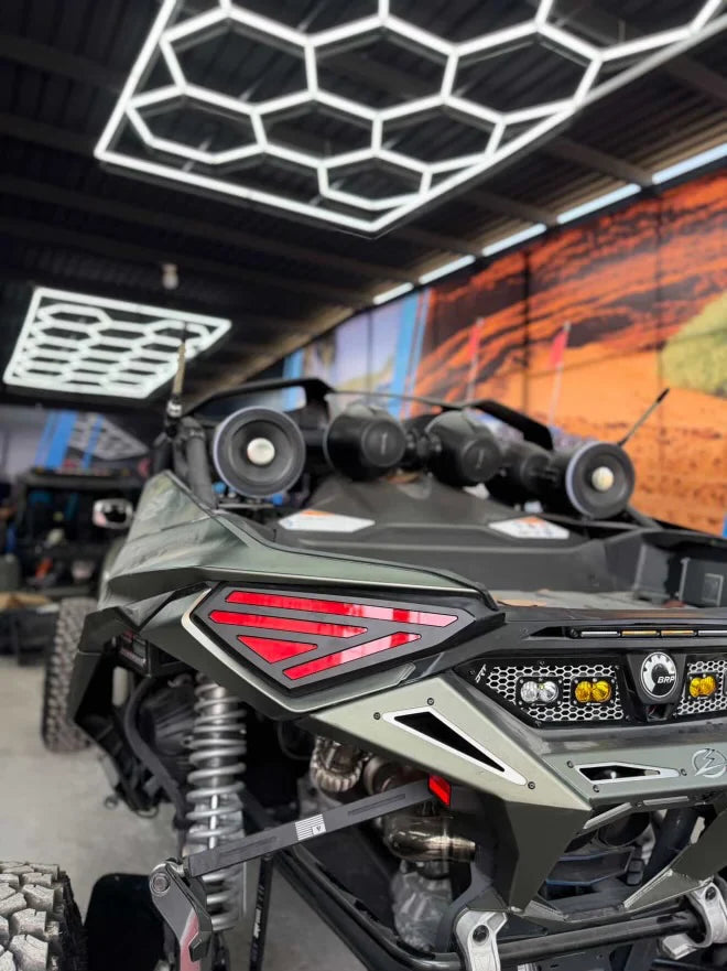 Close-up of an off-road vehicle in a showroom with a geometric ceiling design.