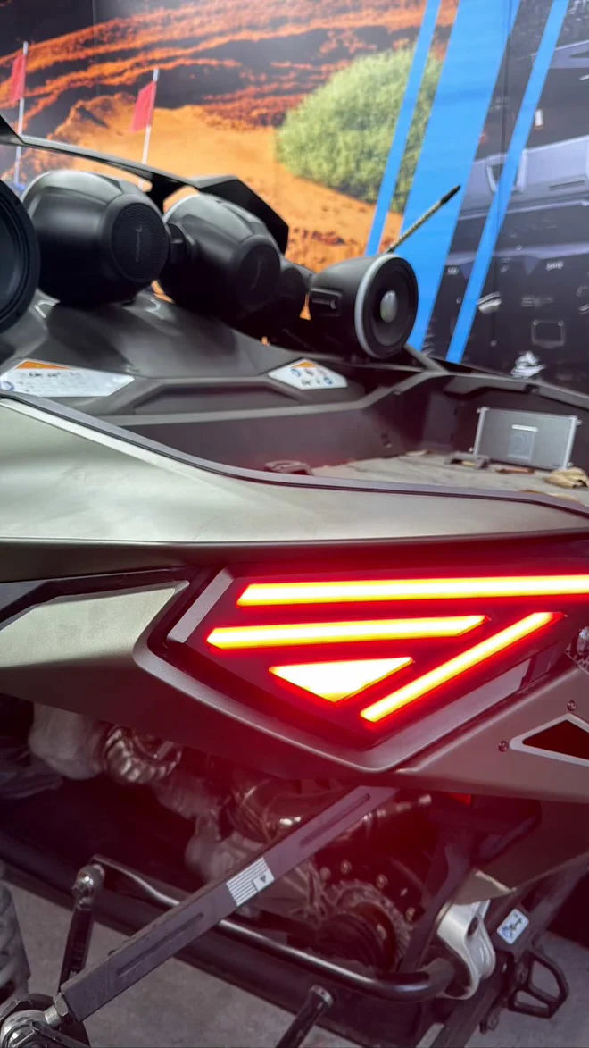 Close-up of a motorcycle's taillight with a scenic background