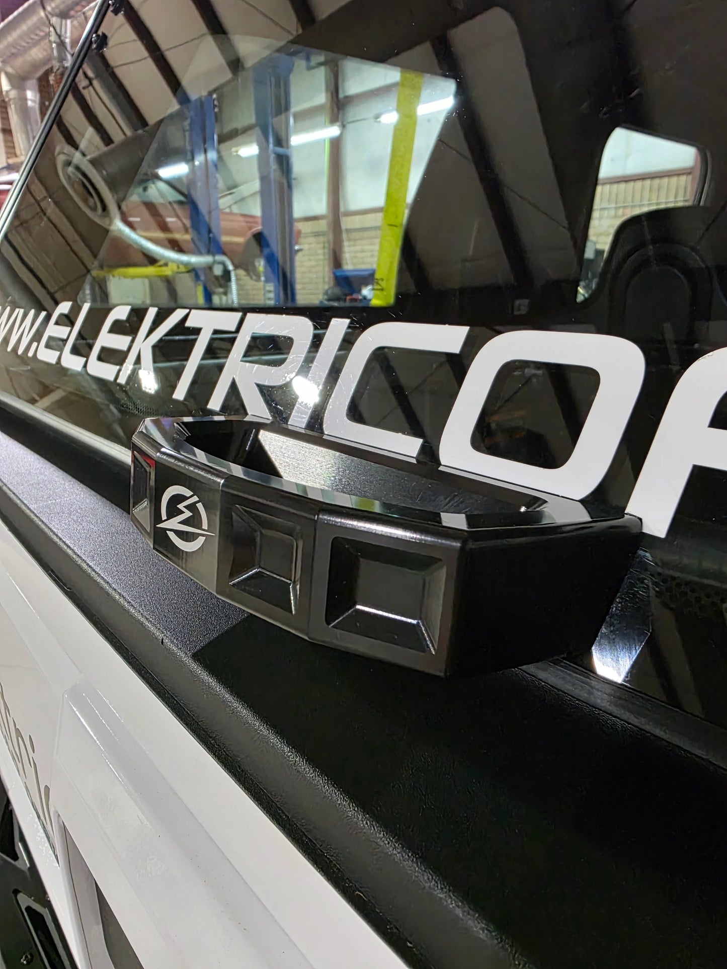 Close-up of a vehicle with 'Elektric' branding on a reflective surface.