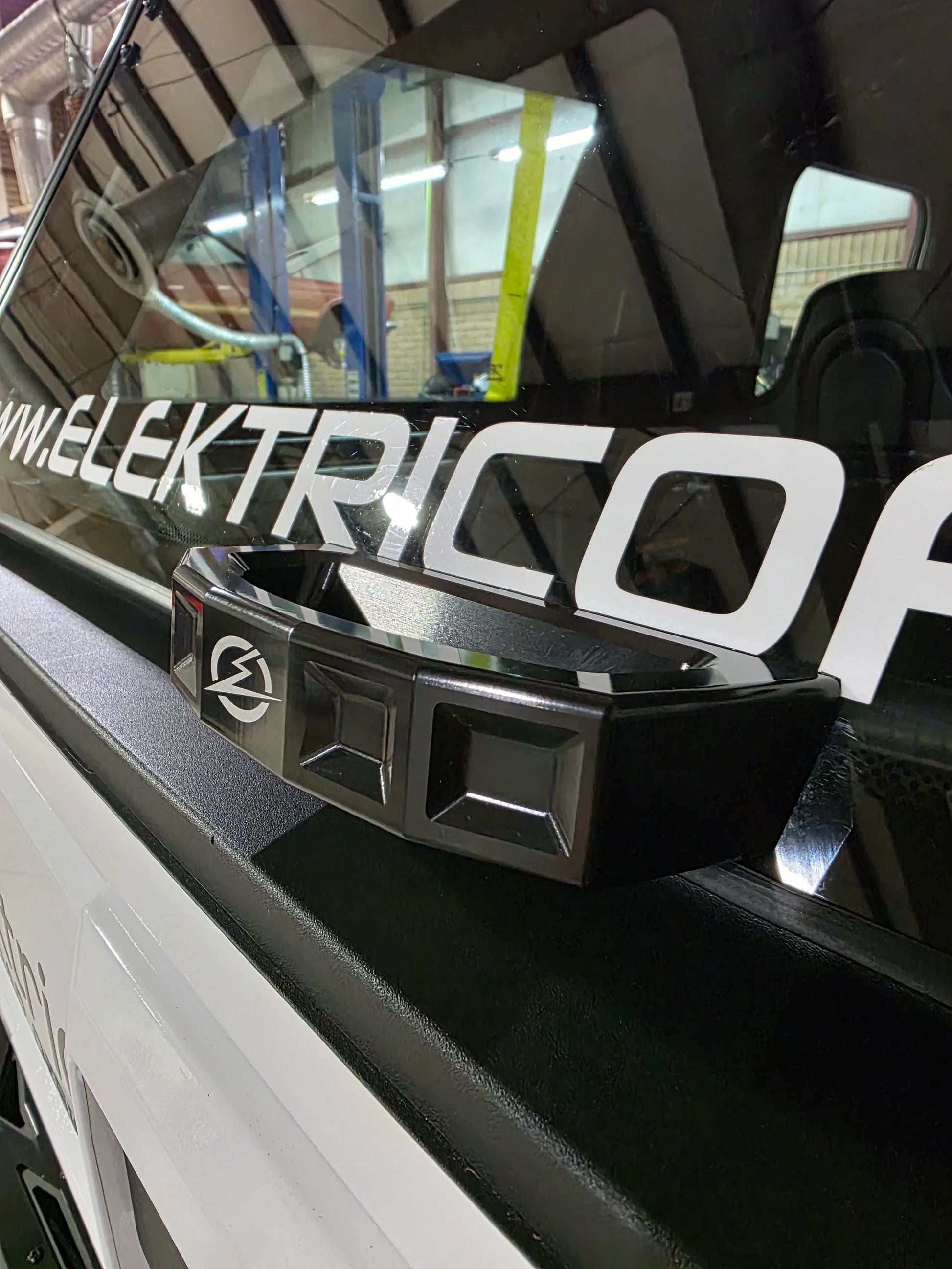 Close-up of a vehicle with 'Elektric' branding on a reflective surface.