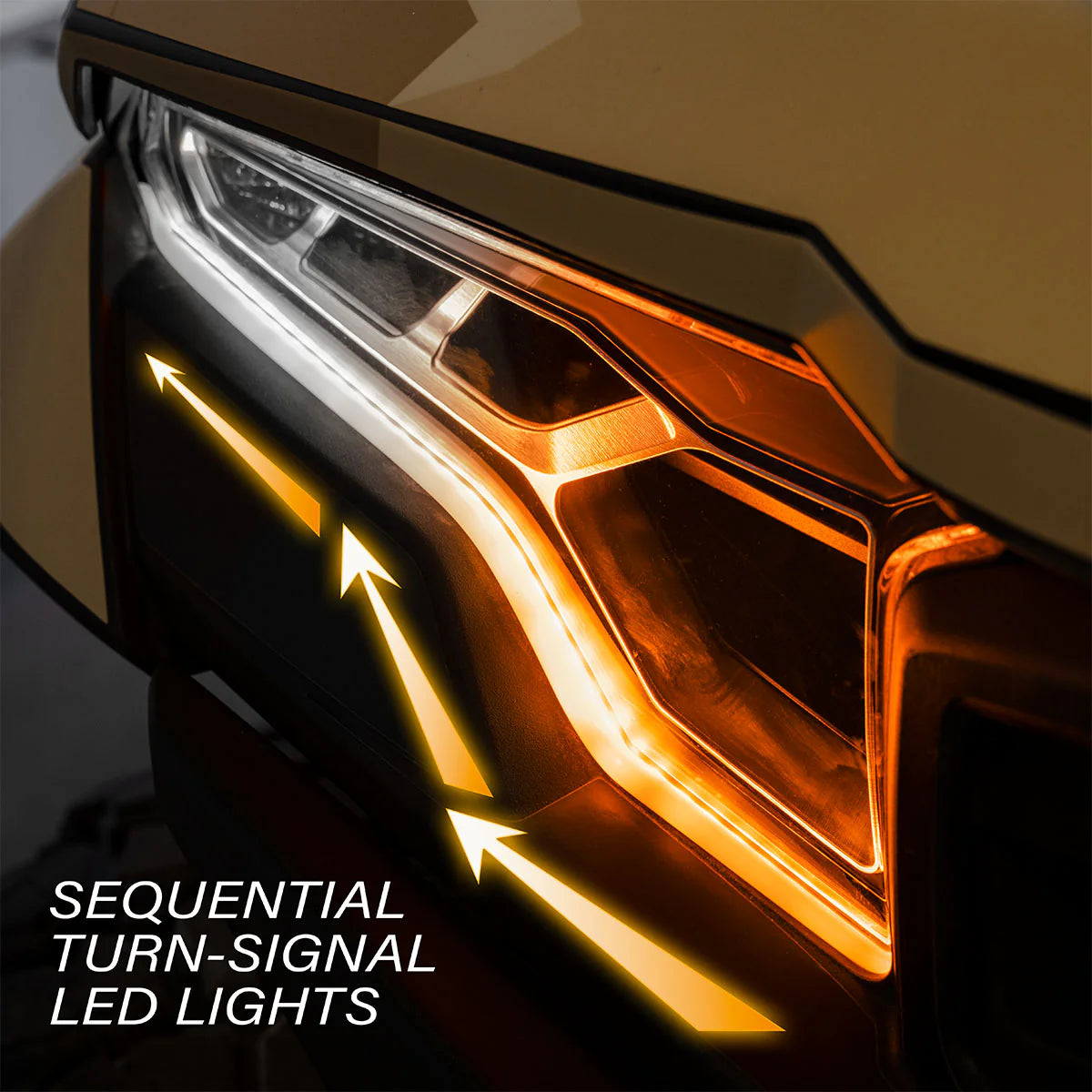 Close-up of a headlight with sequential turn-signal LED lights on a dark background.