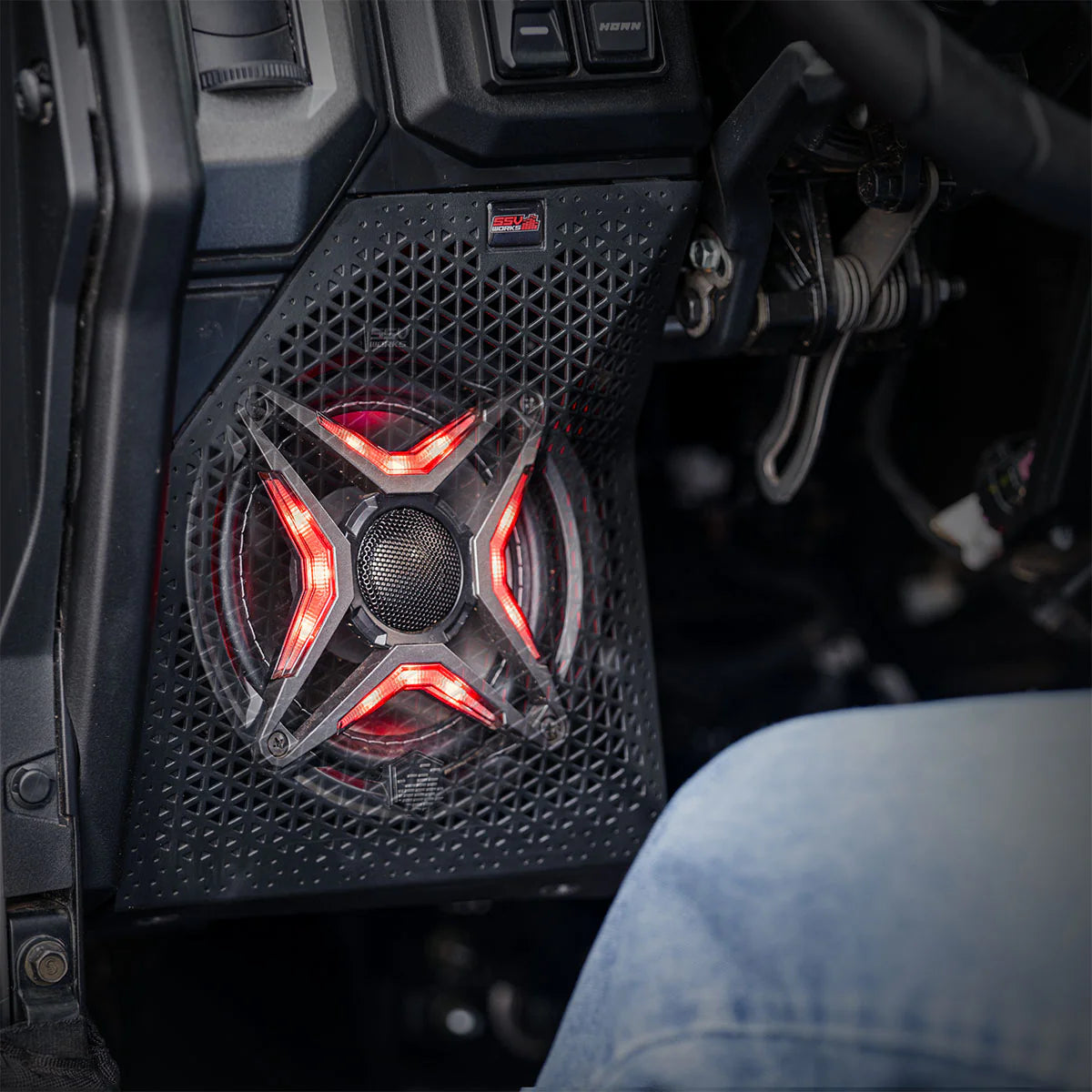 Car audio speaker with red lighting inside a vehicle