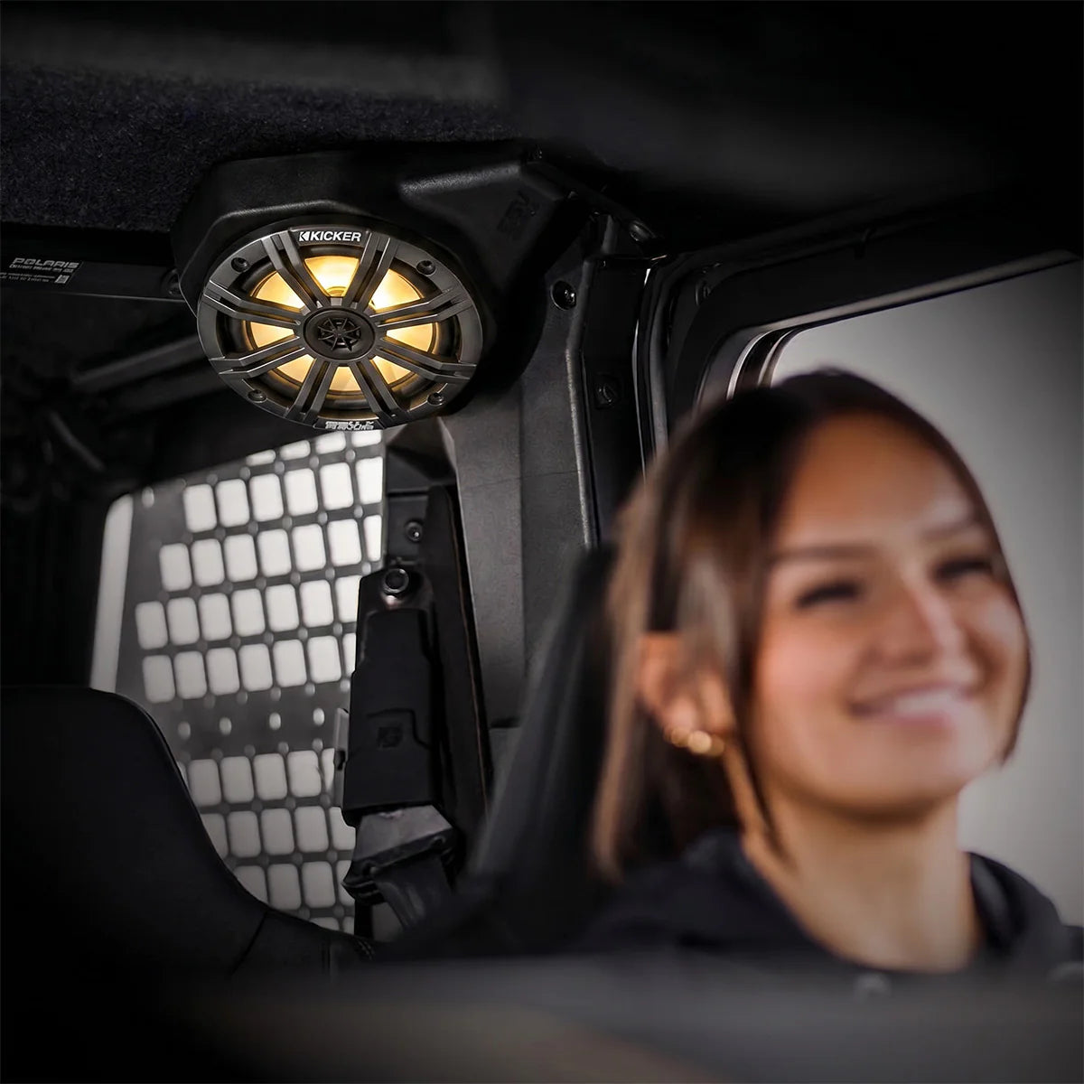 Person sitting inside a vehicle with a mounted speaker system
