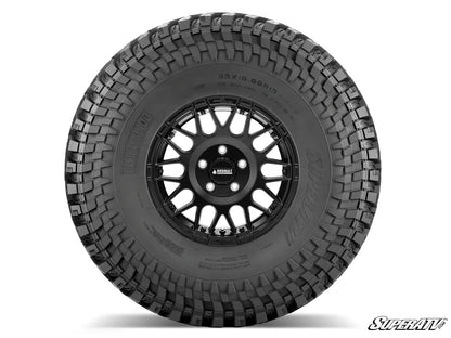 Black tire with a detailed tread pattern on a white background