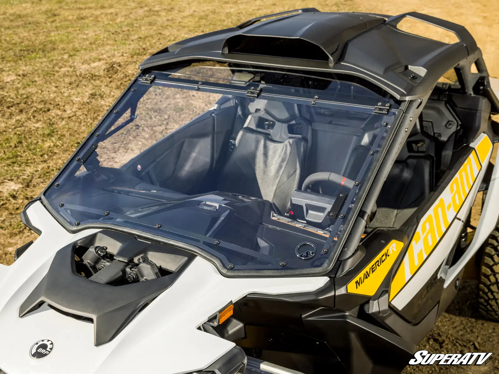 Side view of a Can-Am vehicle with a transparent windshield on a grassy background