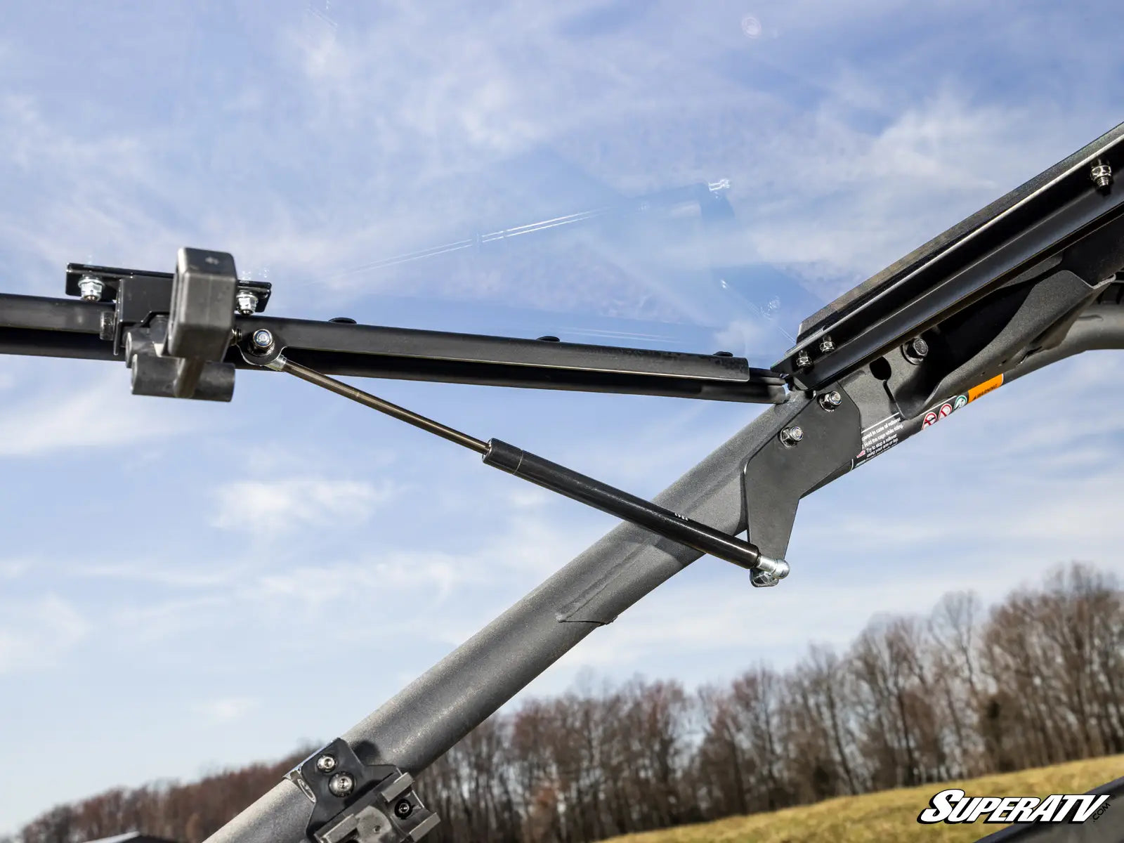 Close-up of a SuperATV product with a clear sky and trees in the background