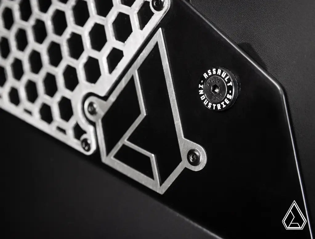 Close-up of a metallic object with geometric design and 'Assault Industries' branding.