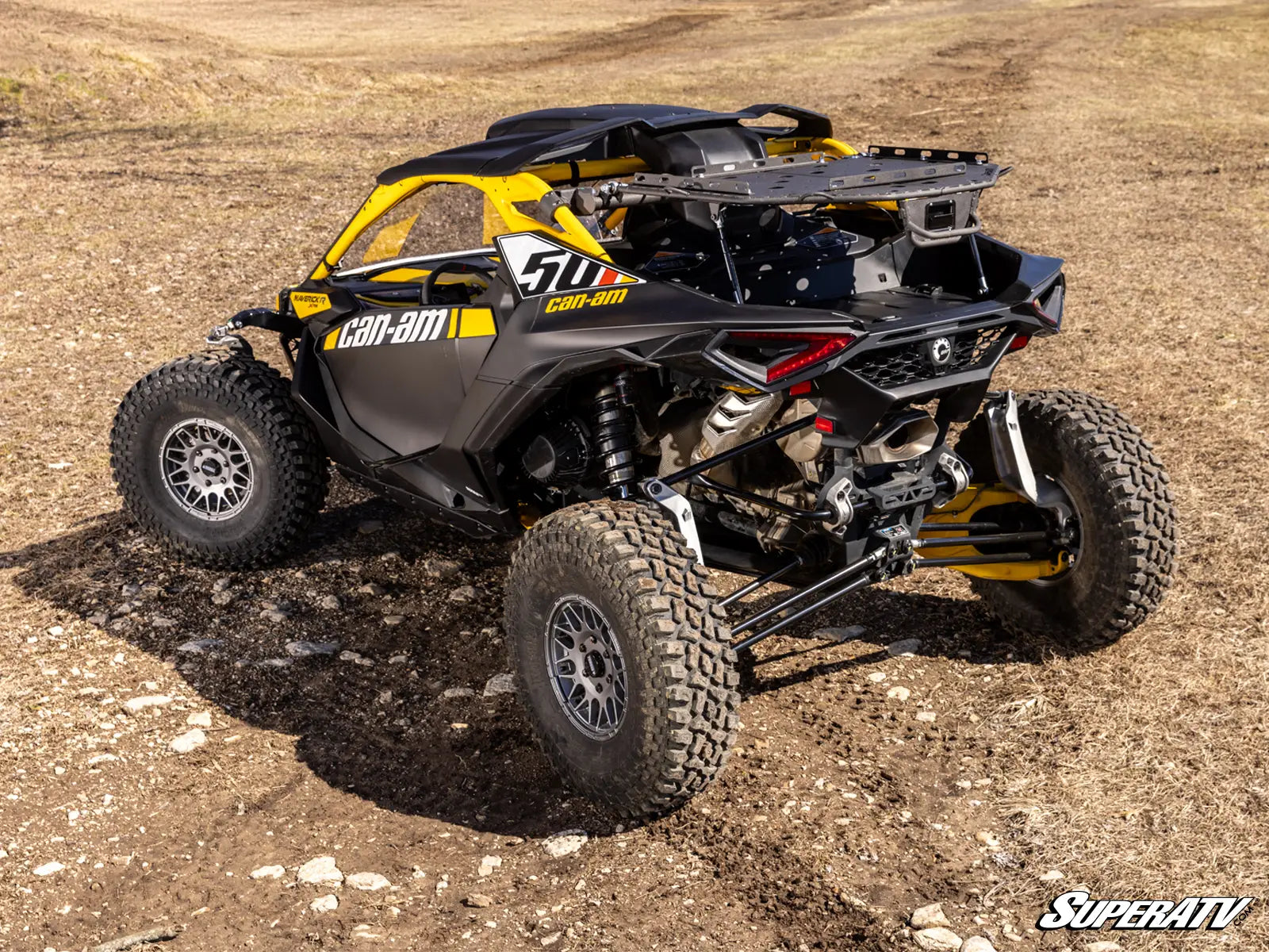 Can-Am off-road vehicle on a dirt surface with 'SuperATV' branding.