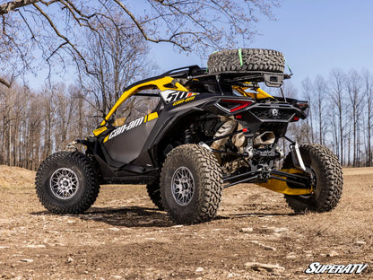 Yellow and black off-road vehicle on a dirt path with trees in the background