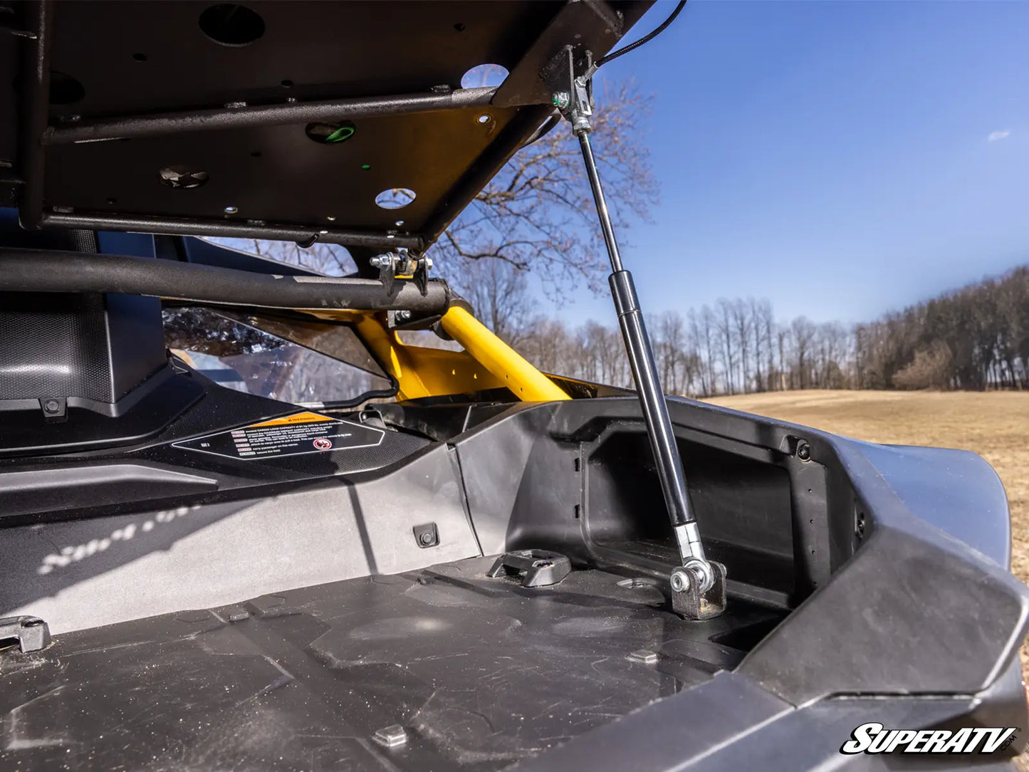 Close-up of a SuperATV product with a clear sky and trees in the background