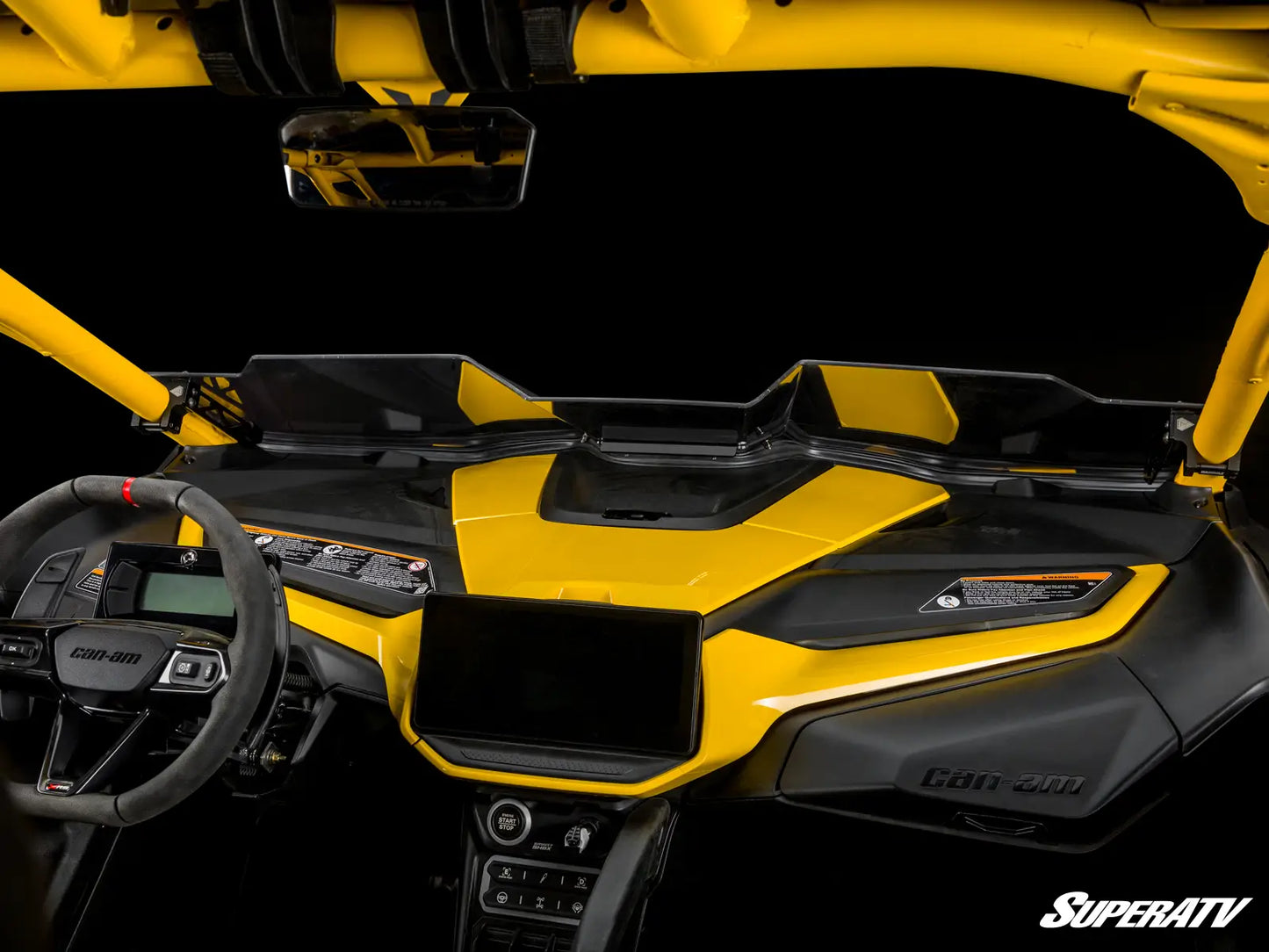 Yellow and black SuperATV vehicle interior with steering wheel and dashboard.