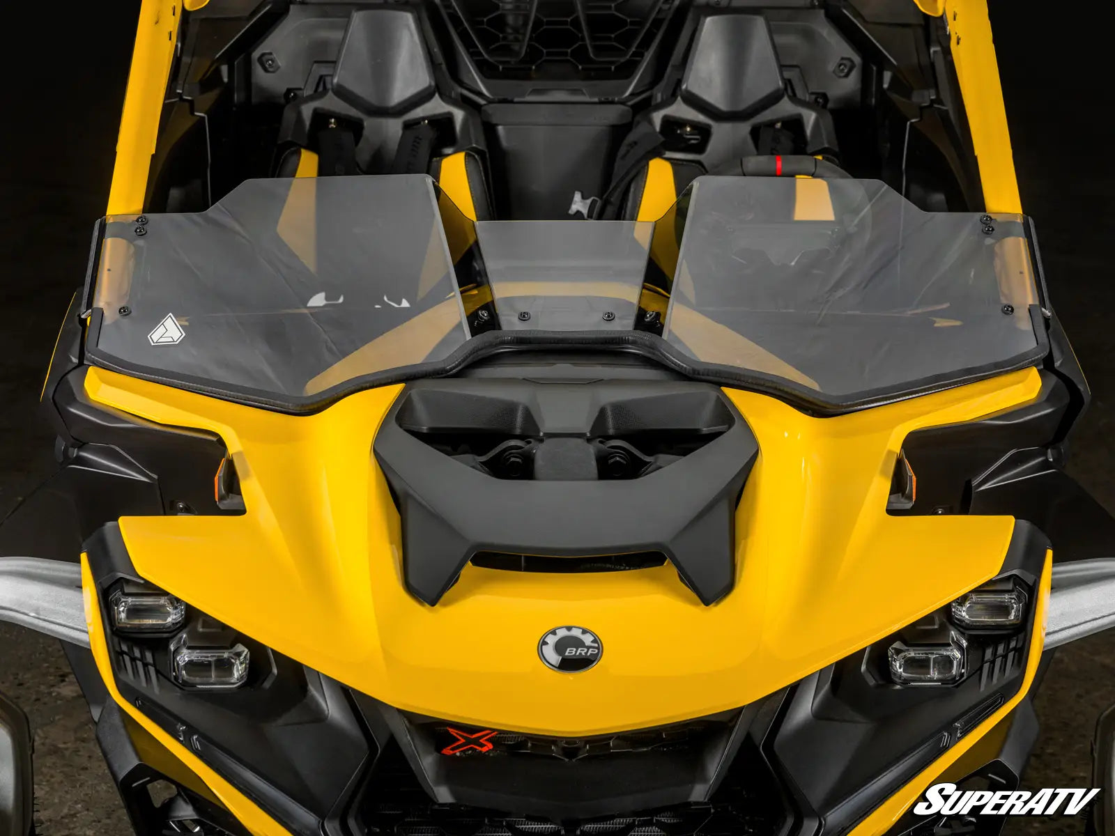 Yellow and black SuperATV vehicle with open doors on a dark background