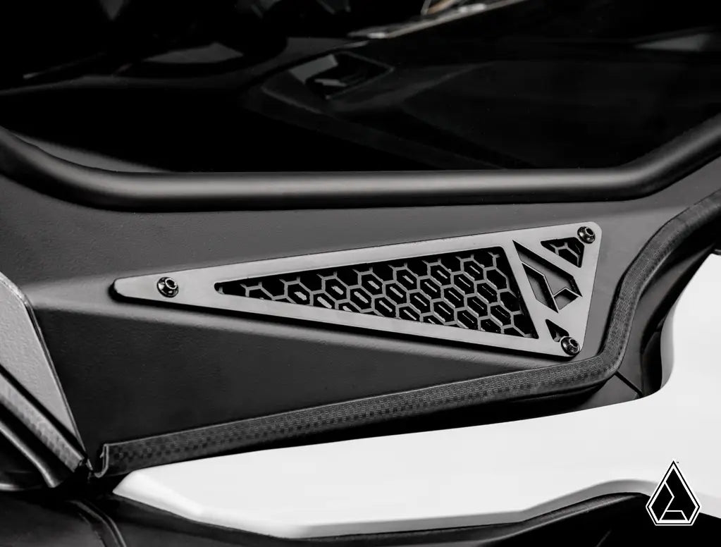 Close-up of a car's air intake grille with a brand logo on a black background