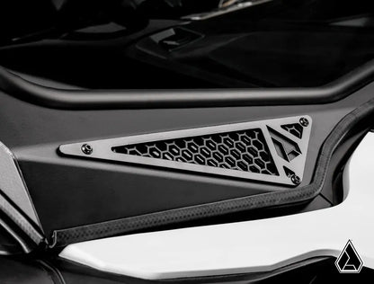 Close-up of a car's air intake grille with a brand logo on a black background