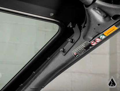 Close-up of a car door panel with warning labels on a gray background