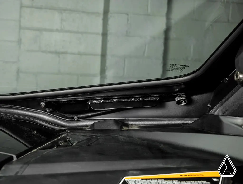 Close-up of a car's windshield wiper mechanism with a blurred background
