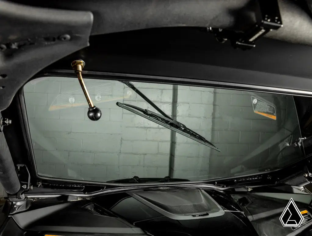 Close-up of a car's windshield wiper mechanism with a blurred background