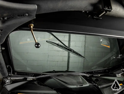 Close-up of a car's windshield wiper mechanism with a blurred background