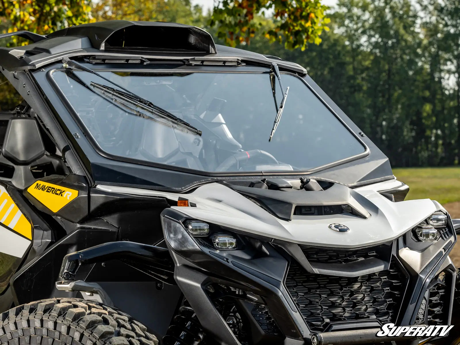 Side view of a SuperATV vehicle with a clear windshield and visible branding.