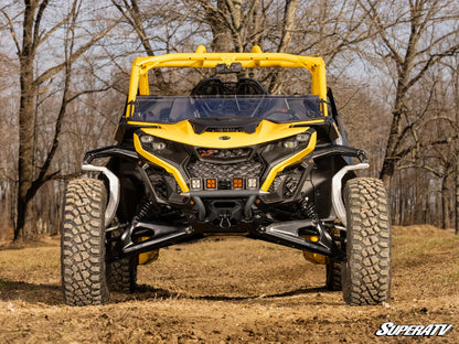 Yellow and black SuperATV vehicle on a dirt path with trees in the background