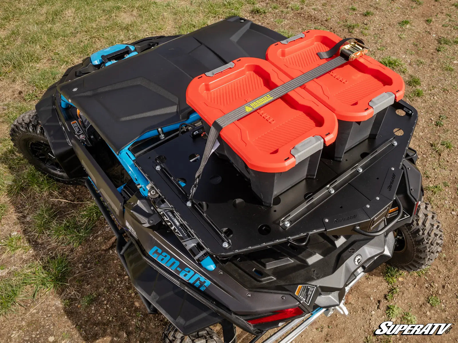 Black UTV with orange storage bins on a grassy field