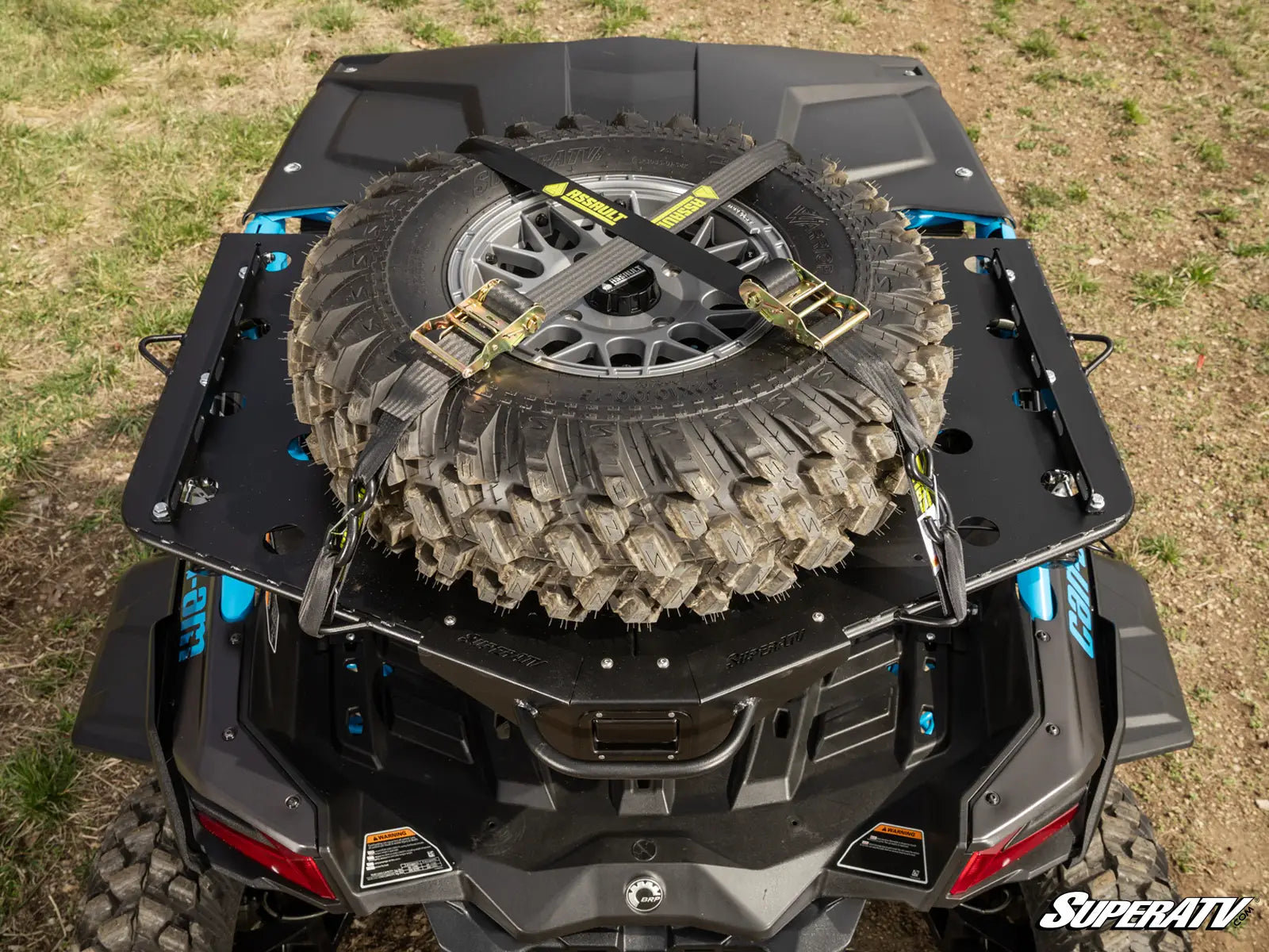Off-road vehicle with a spare tire mounted on the back, on a grassy field.