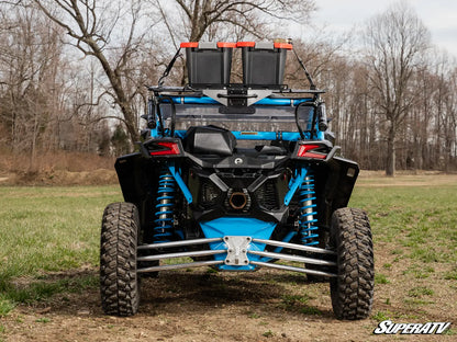 Blue and black off-road vehicle with additional storage on a grassy field.