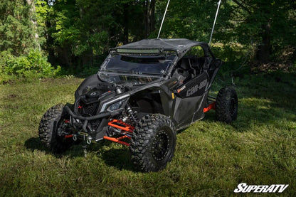 Black off-road vehicle on grass with trees in the background