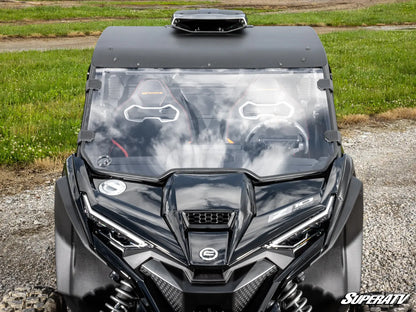 Black SuperATV vehicle with a clear windshield on a gravel surface.