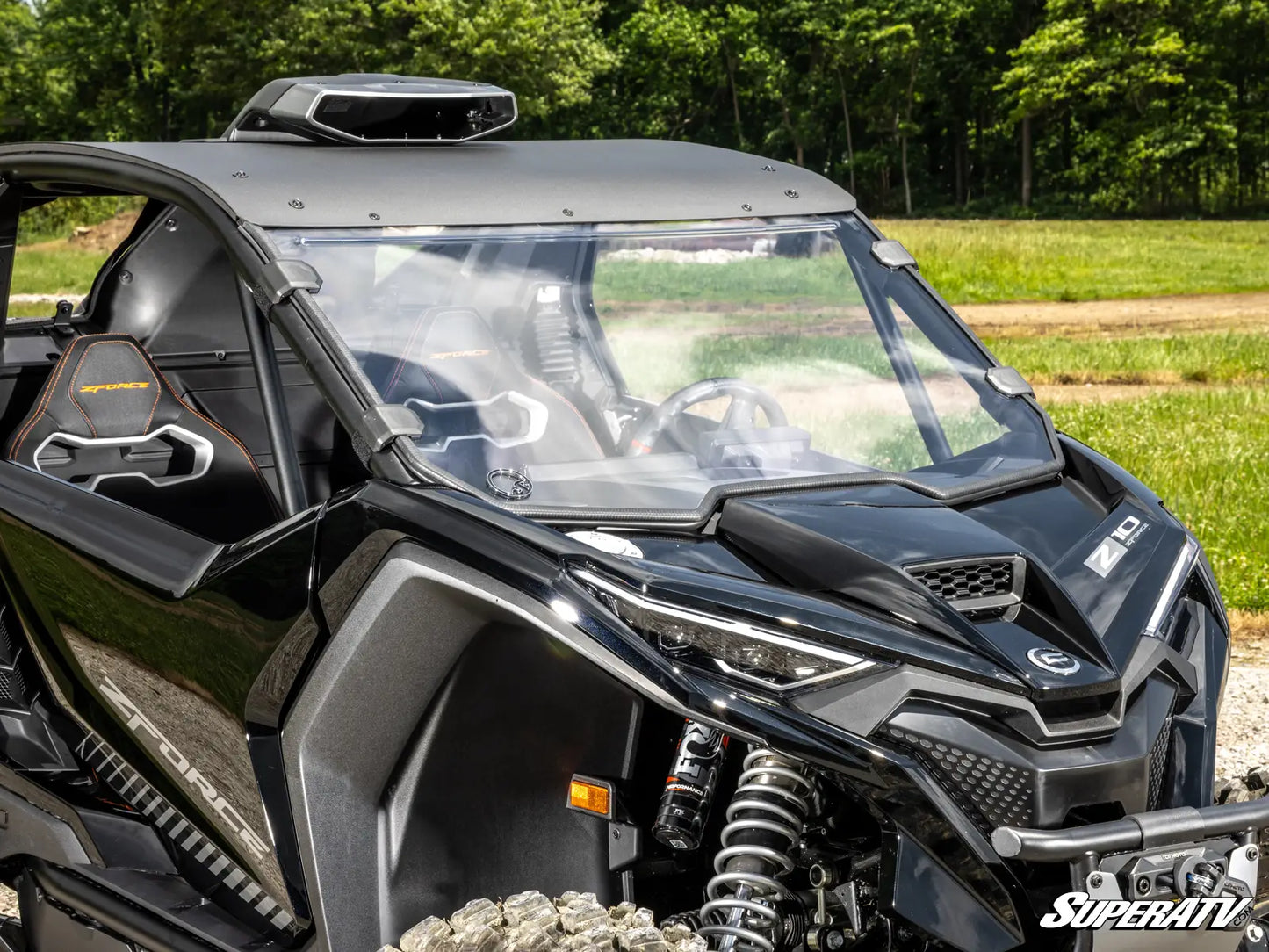 Black off-road vehicle with 'SuperATV' branding in a natural setting