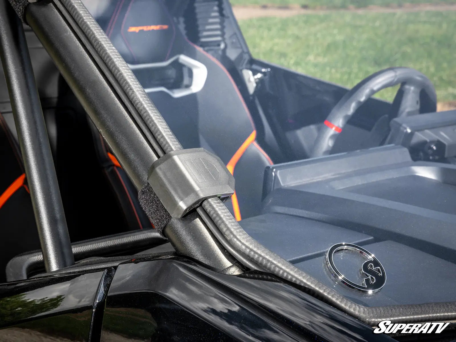 Close-up of a vehicle interior with a SuperATV logo on the steering wheel.