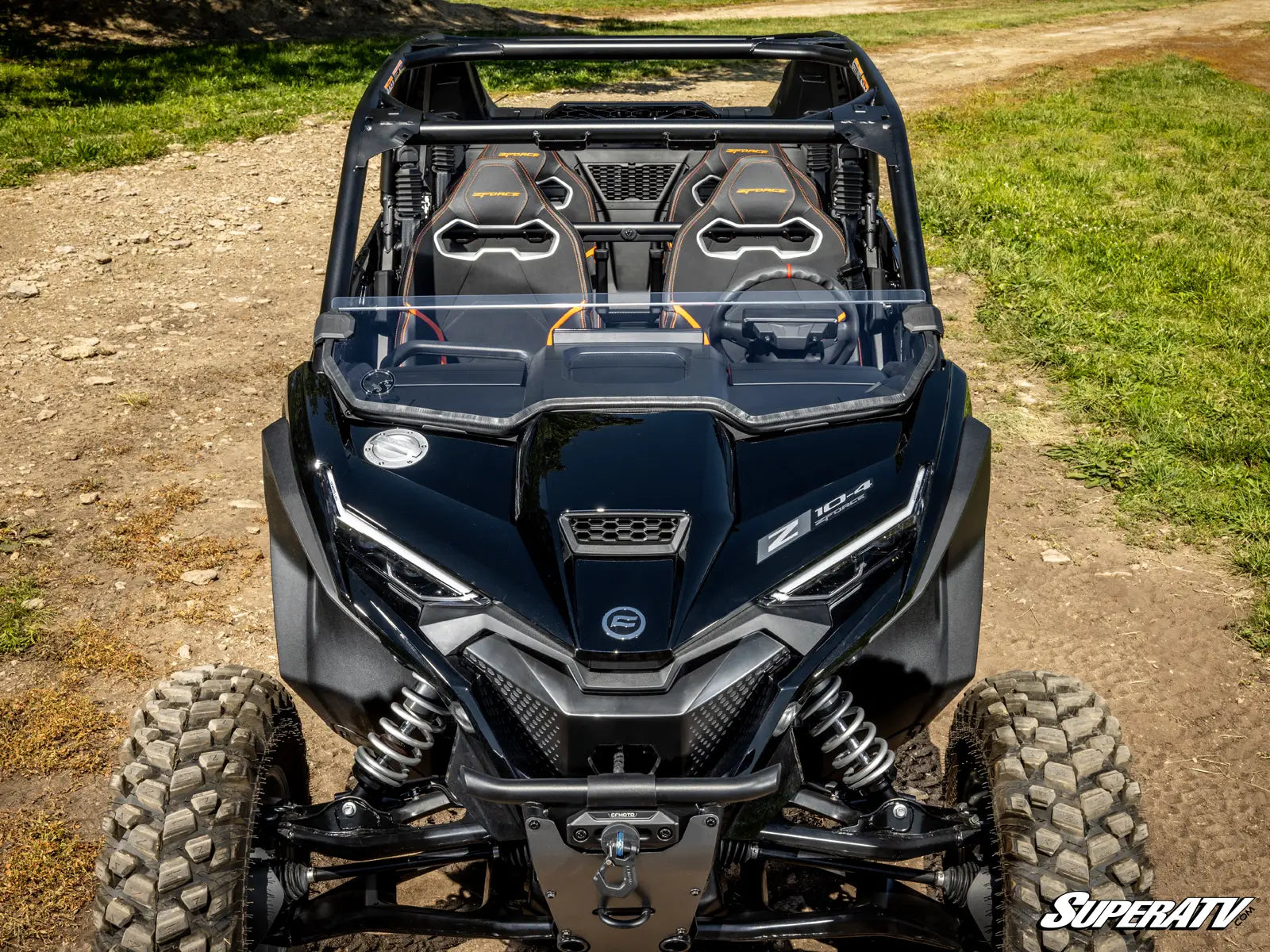 Black SuperATV vehicle on a dirt path with grass in the background
