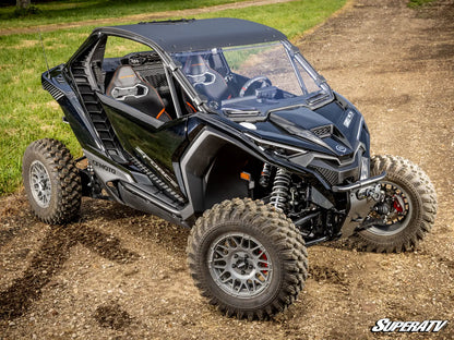 Black off-road vehicle on a dirt path with grass in the background