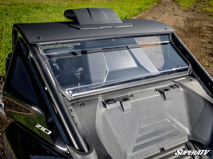 A close-up outdoor shot of the rear cabin area of a black off-road vehicle, showing a clear windshield, dark roof trim, and a gray interior panel. The word 'SUPER ATV' appears in the bottom right corner.