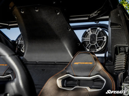 Close-up of a black and gray racing bucket seat with orange stitching and 'ZFORCE' embroidered on the backrest, installed inside a vehicle with a roll cage and speaker visible.