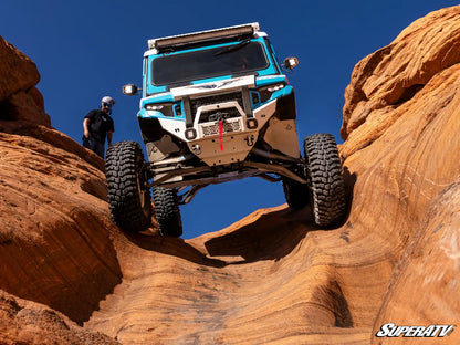 Off-road vehicle navigating rocky terrain with 'SuperATV' branding.