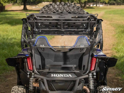 Honda ATV with SuperATV equipment in a grassy field