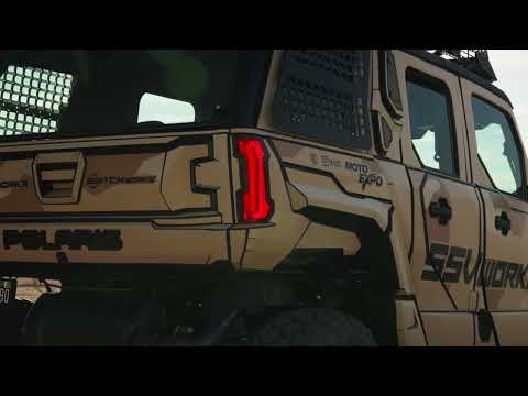 Tan off-road vehicle with visible branding and text on a blurred background