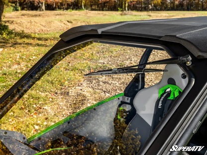 Close-up of a SuperATV vehicle with a windshield and wipers, outdoors.