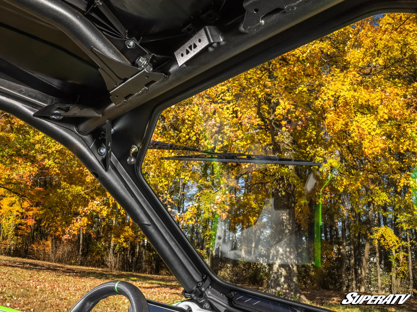 View from inside a vehicle looking out at autumn trees with SuperATV branding.
