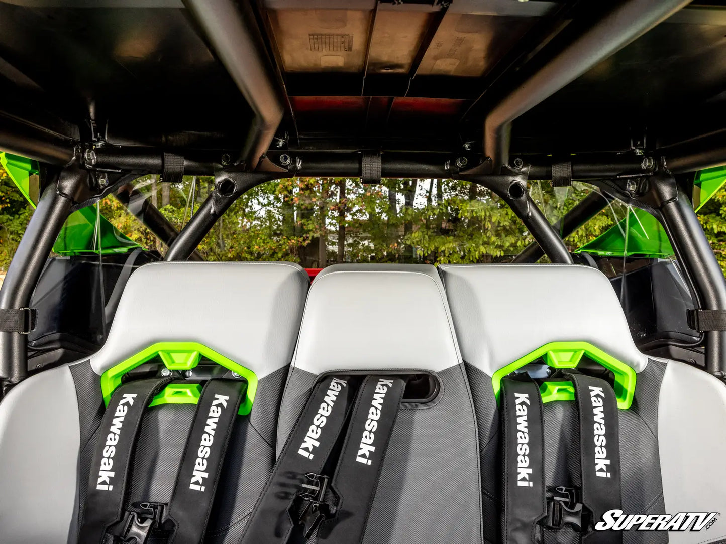 Kawasaki SuperATV seats inside an off-road vehicle with green accents.