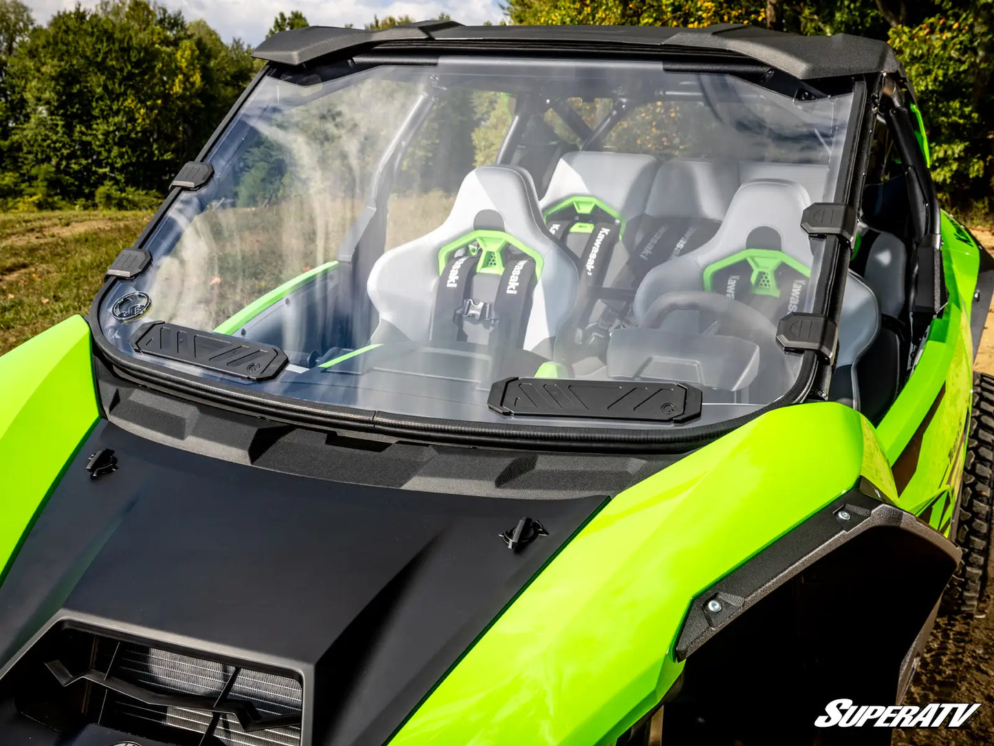 Close-up of a lime green and black SuperATV vehicle with a clear windshield.