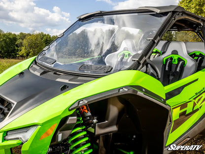 Green and black off-road vehicle with 'SuperATV' branding in a natural setting.