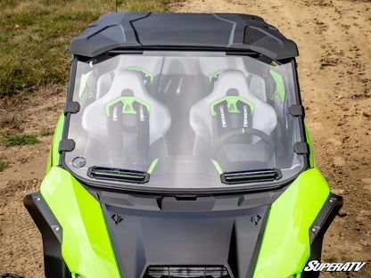 Close-up of a SuperATV windshield on an off-road vehicle with a dirt background.