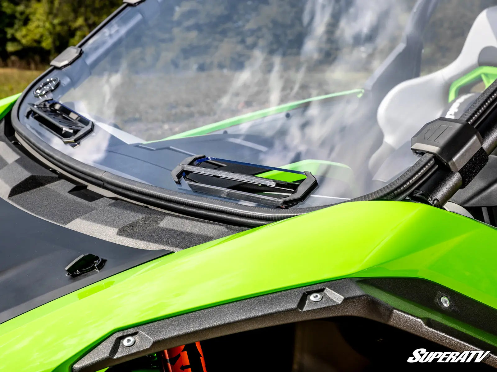 Close-up of a green ATV with a clear windshield, featuring the SuperATV logo.