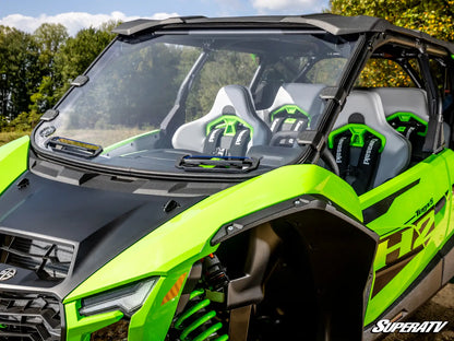 Green and black off-road vehicle with 'SuperATV' branding in a natural setting.