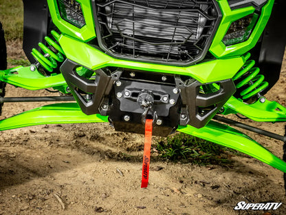 Close-up of a green ATV with a SuperATV logo on a dirt surface.