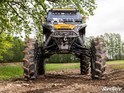 Large off-road vehicle with massive tires in a forested area, featuring the SuperATV logo.