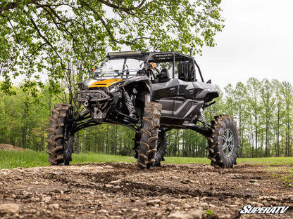 SuperATV off-road vehicle on a dirt path with trees in the background